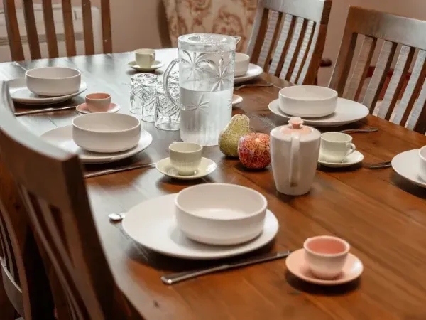 A wooden table with plates bowls and cups on it