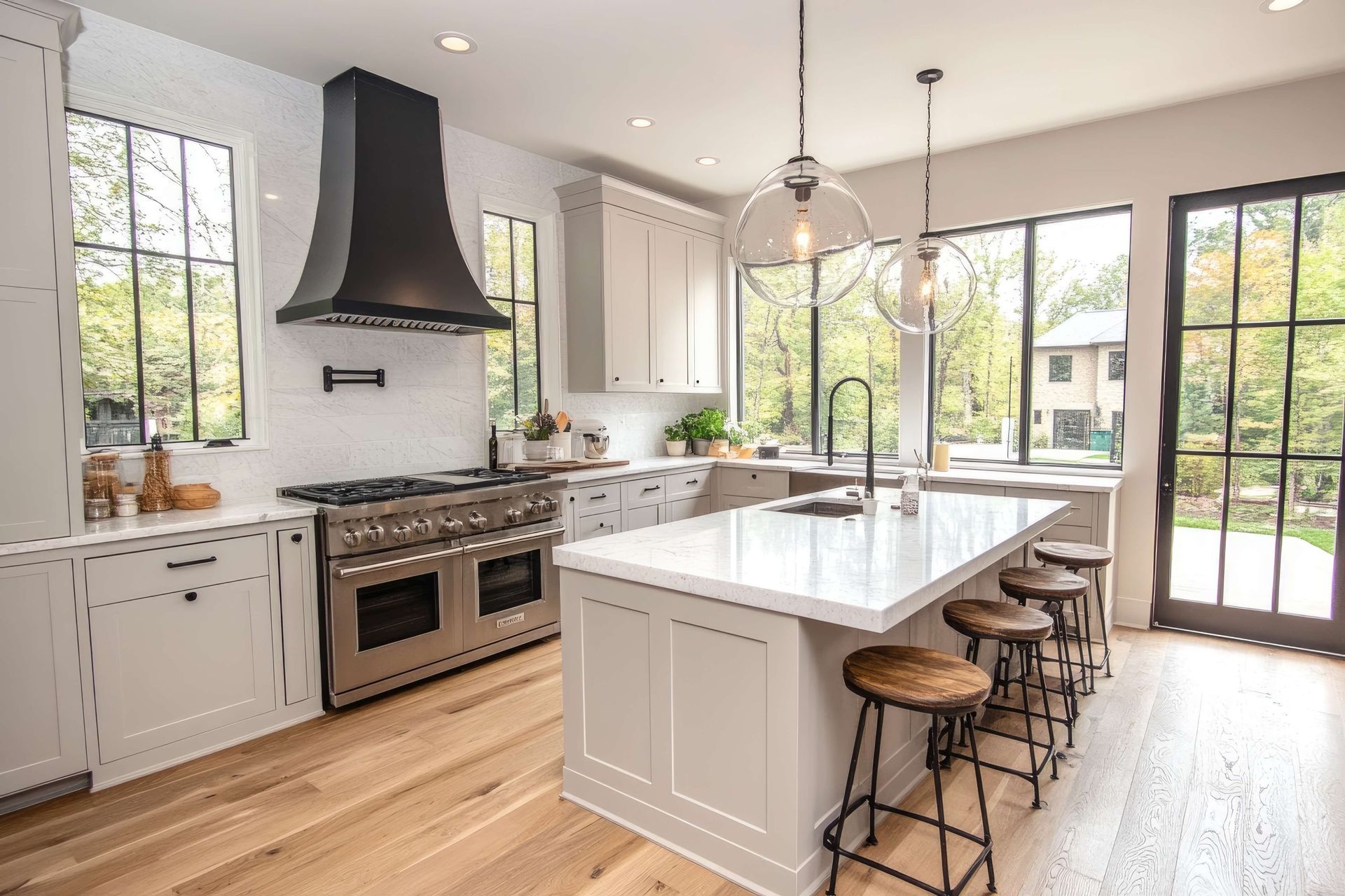 A kitchen with white cabinets , stainless steel appliances , and a large island.