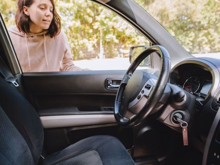 A woman is looking out the window of a car.