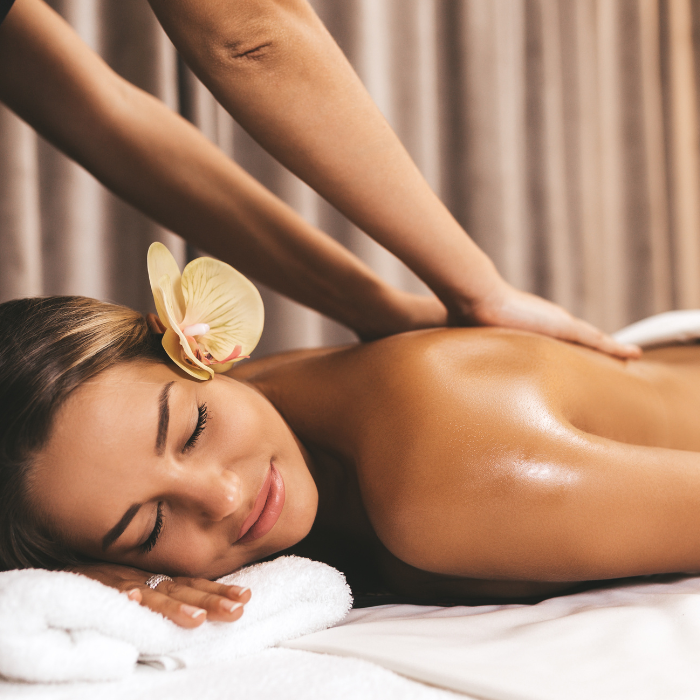 A woman with a flower in her hair is getting a massage