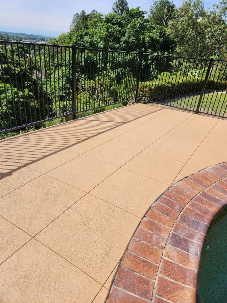 A Patio With A Fence And A Pool In The Background — Core Concrete in Cairns, QLD