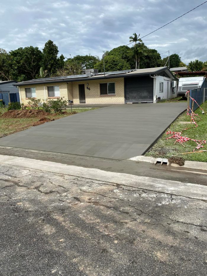 A Concrete Driveway is Being Built in Front of a House — Core Concrete in Innisfail, QLD