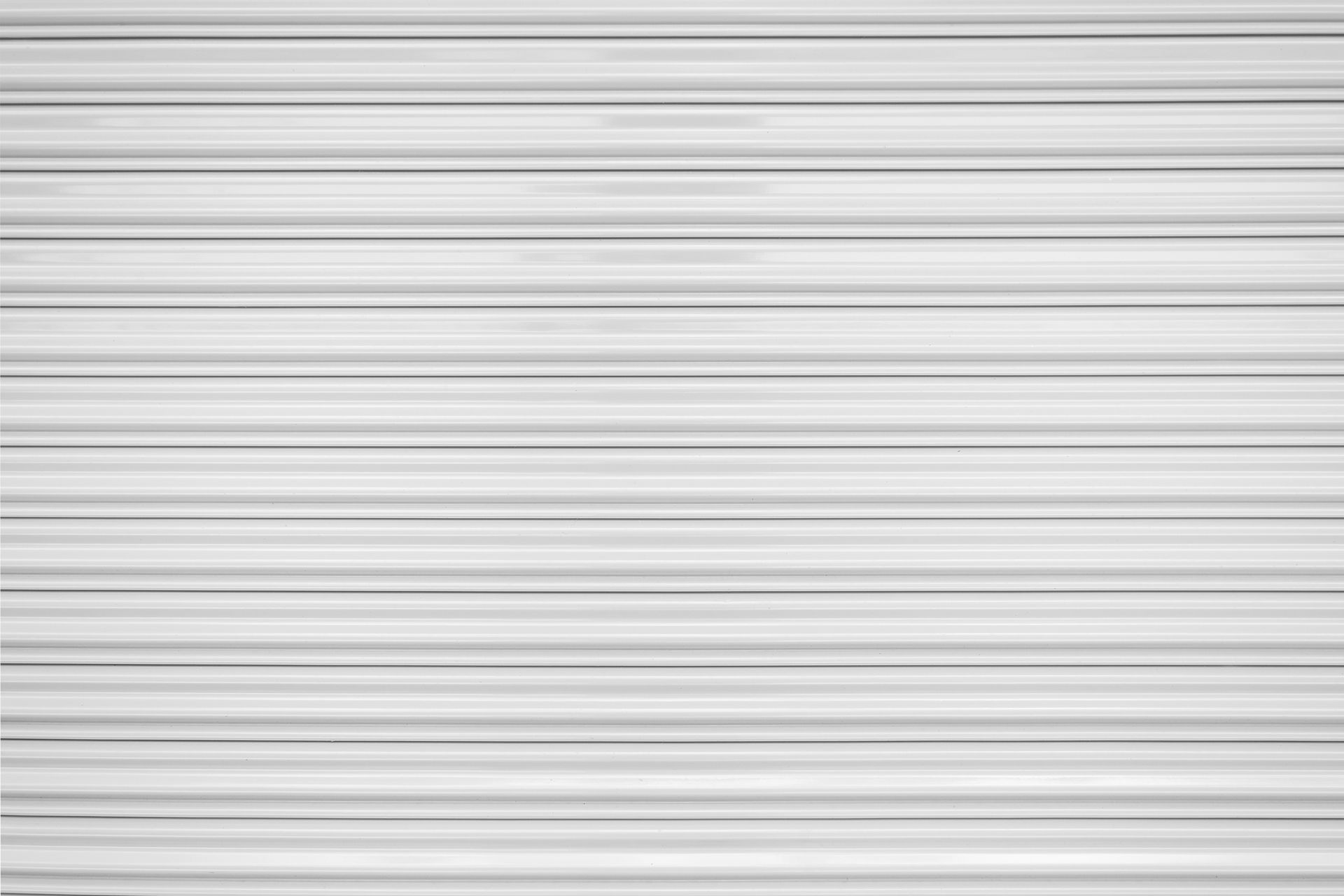 White metal roller door backdrop, perfect for highlighting hurricane shutters in North Port, FL. 