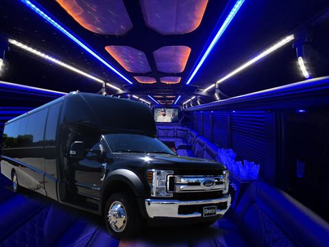 Black party bus interior with blue and white LED lights, exterior shot of the bus, daytime.