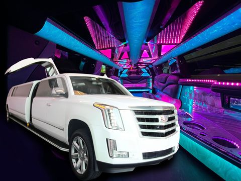 White limousine with open doors, neon lit interior.
