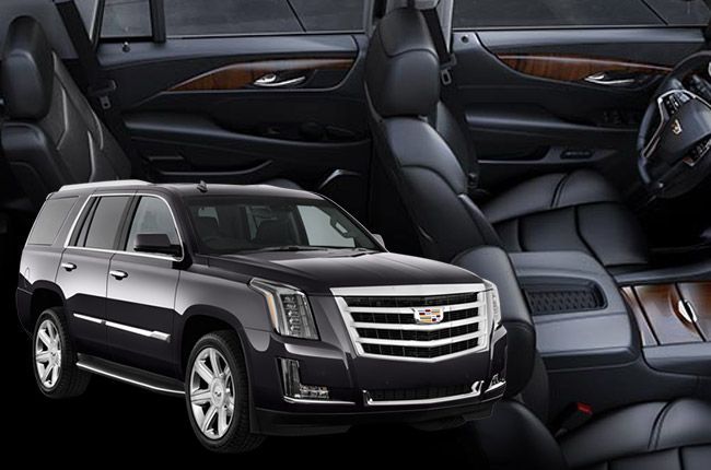 Black Cadillac Escalade SUV with dark leather interior and woodgrain accents.