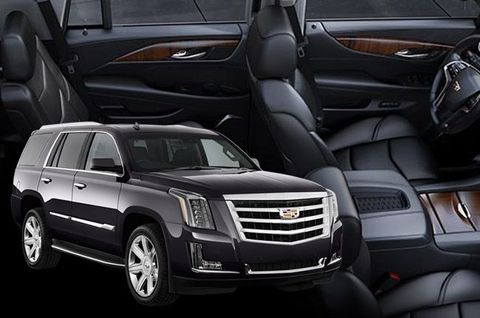 Black Cadillac Escalade SUV with dark leather interior and wood trim.