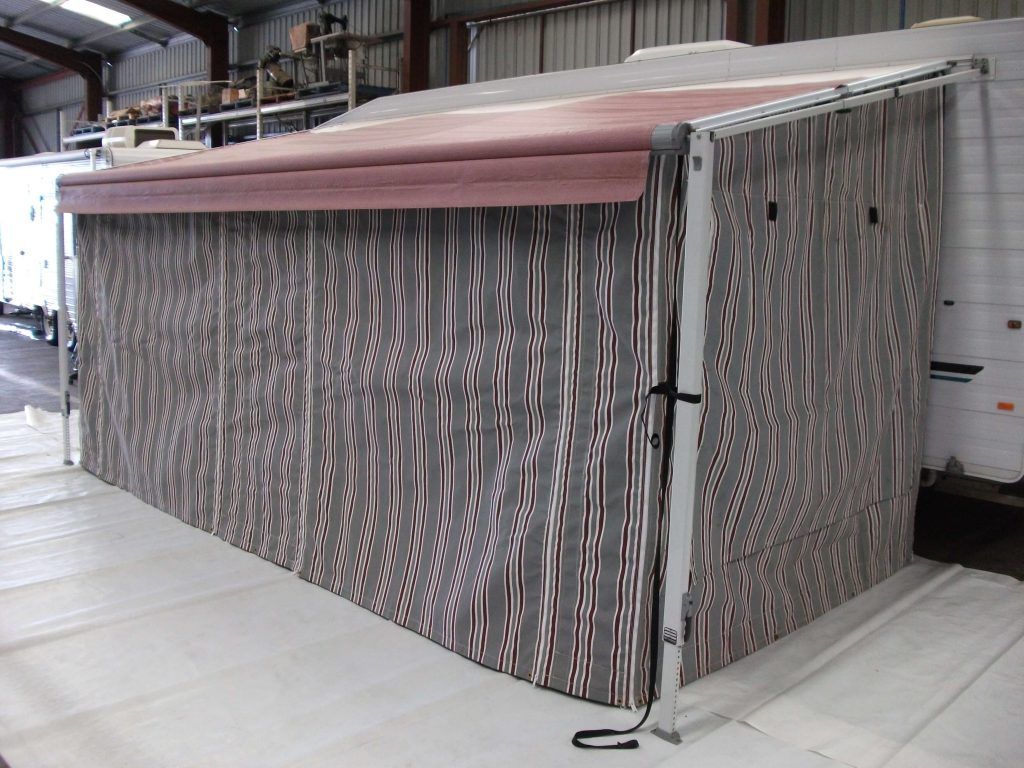 A striped enclosed awning system, in an industrial setting.