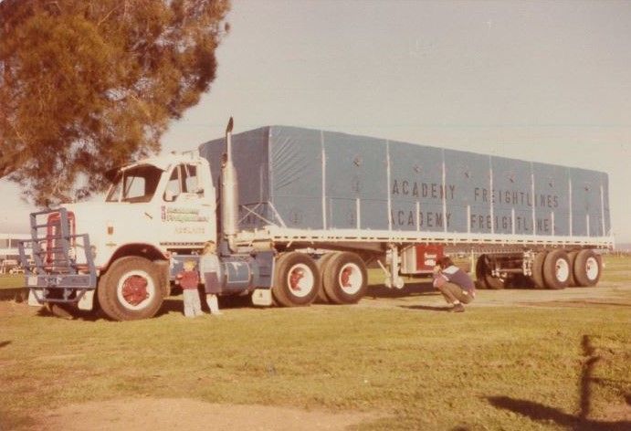 White truck with blue trailer marked