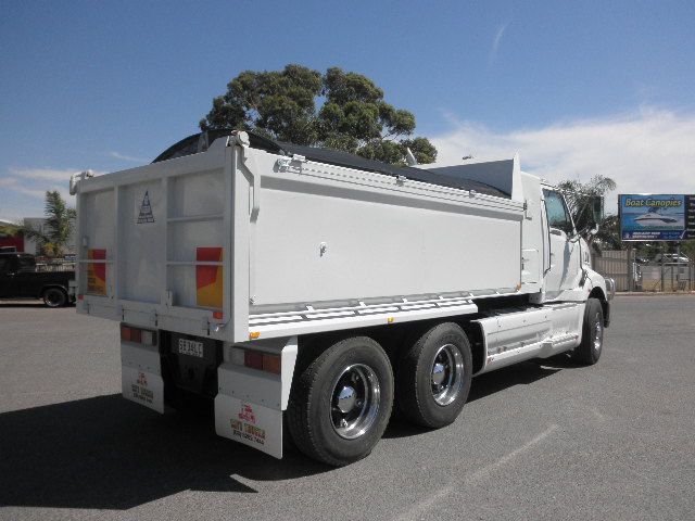 White dump truck parked on pavement.