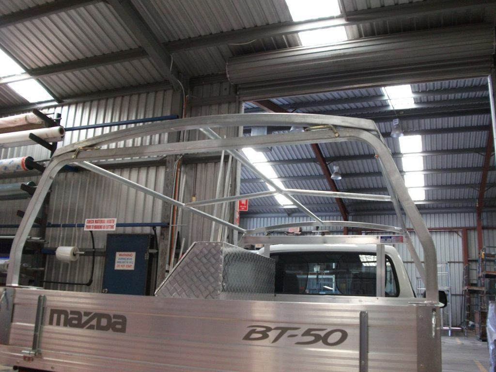 Aluminum frame installed on a Mazda BT-50 truck bed inside a workshop.