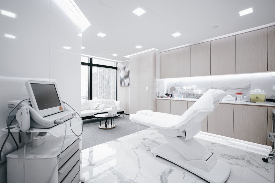 Aesthetic treatment room with medical equipment, a treatment chair, and a waiting area.