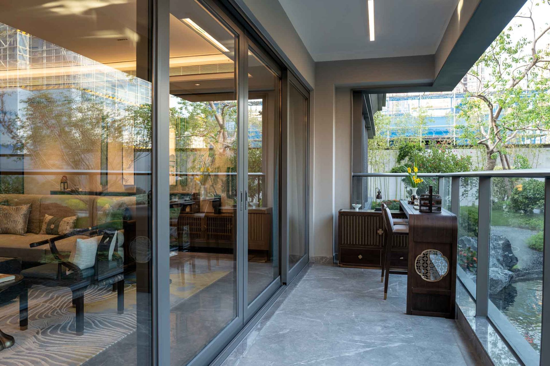 A balcony with sliding glass doors and a desk in a living room.