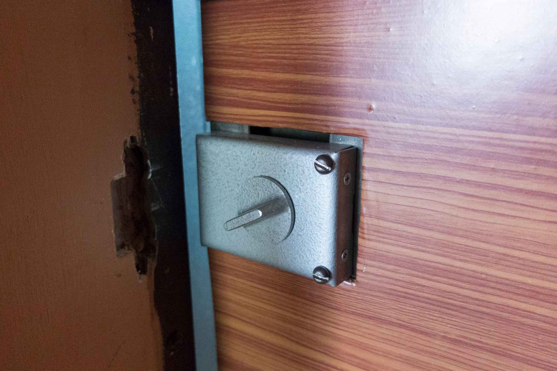 A close up of a door lock on a wooden door.