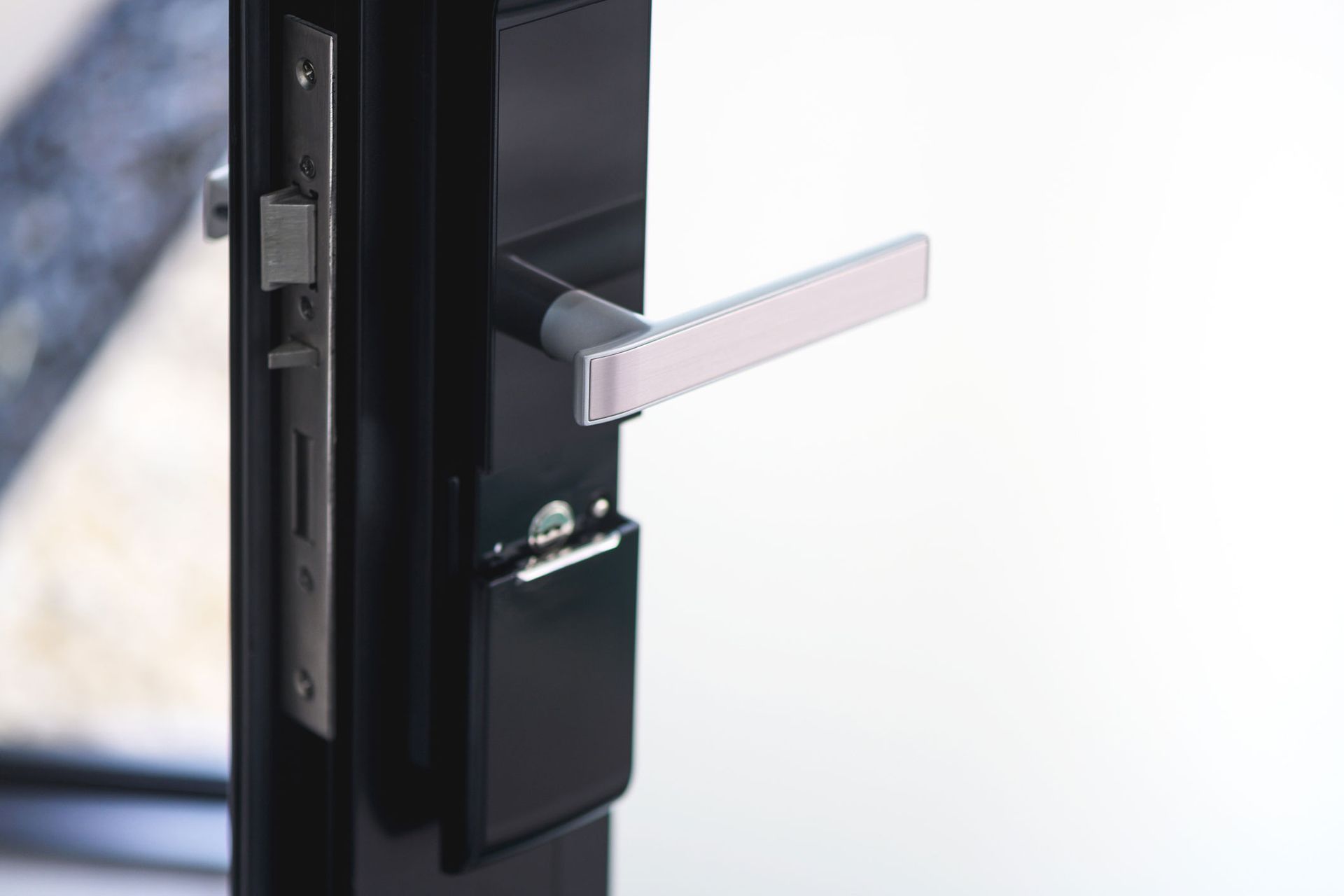 A close up of a black door with a white handle.