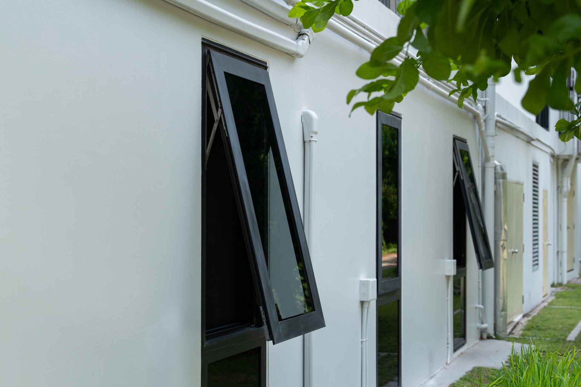 A white building with a black window on the side of it.