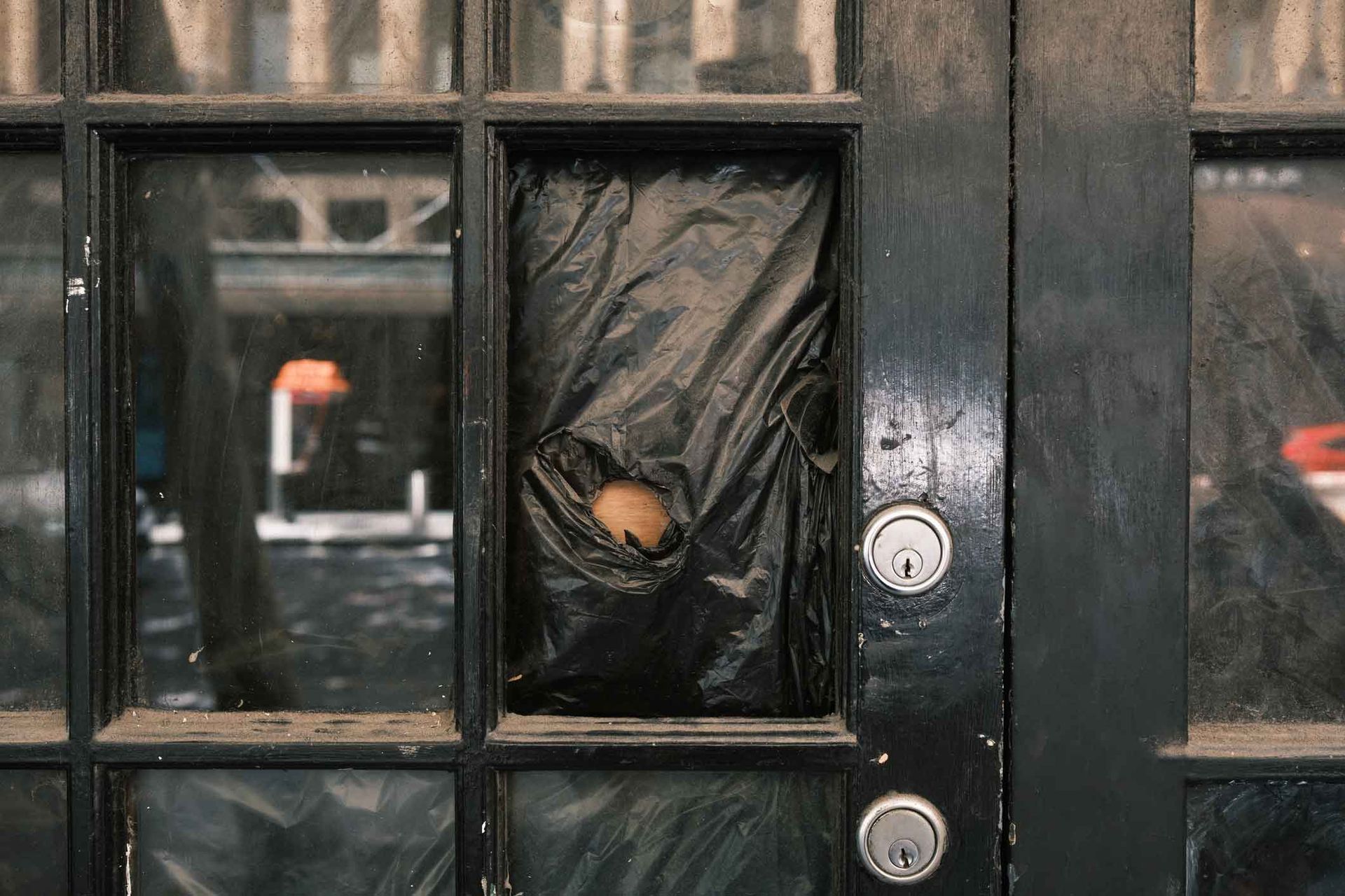 A person is sticking their head through a hole in a door.