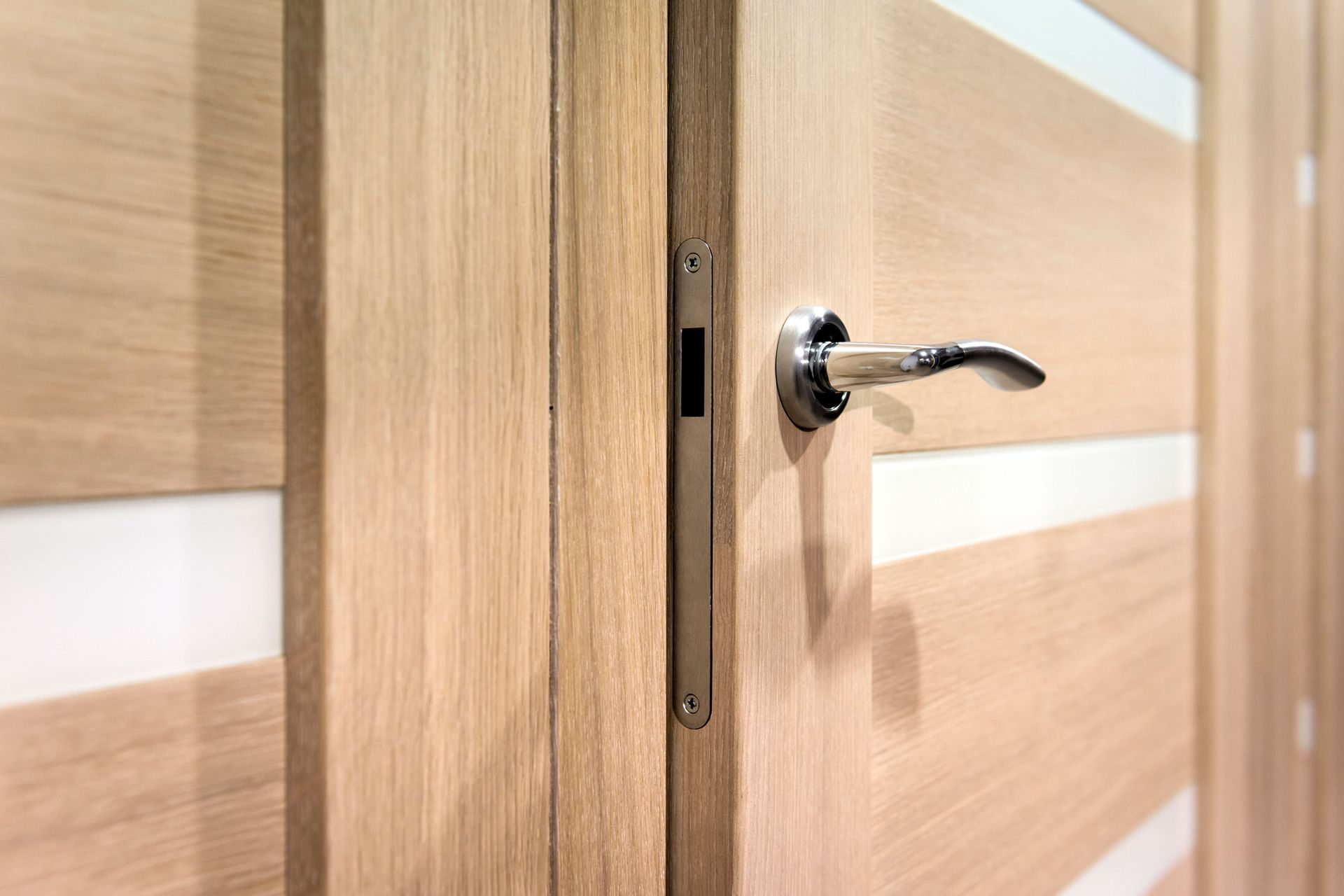 A close up of a door handle on a wooden door.