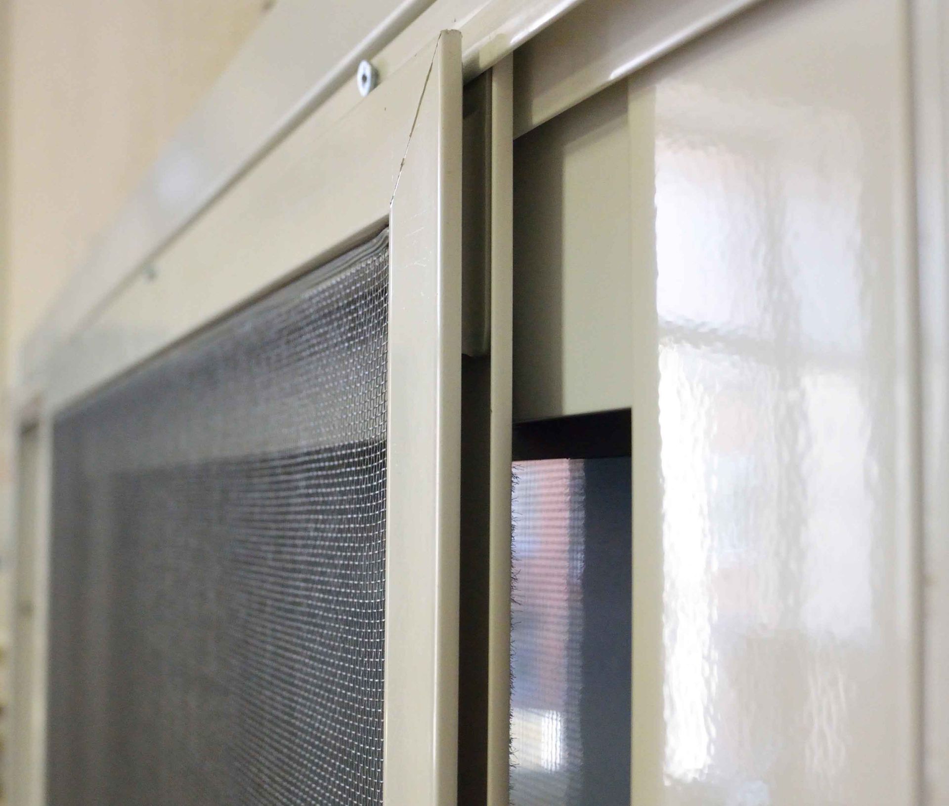 A close up of a sliding screen door in a room.
