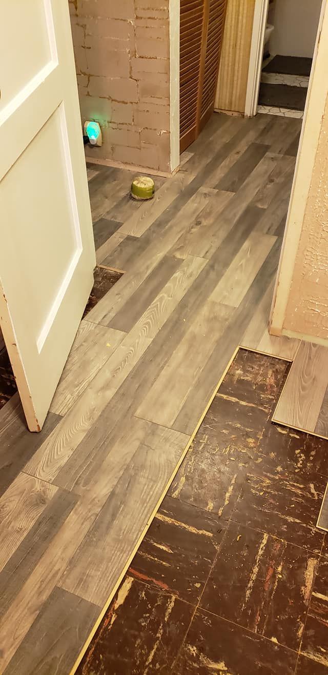 Hallway with wood flooring, two balls, and open doorways leading to a room