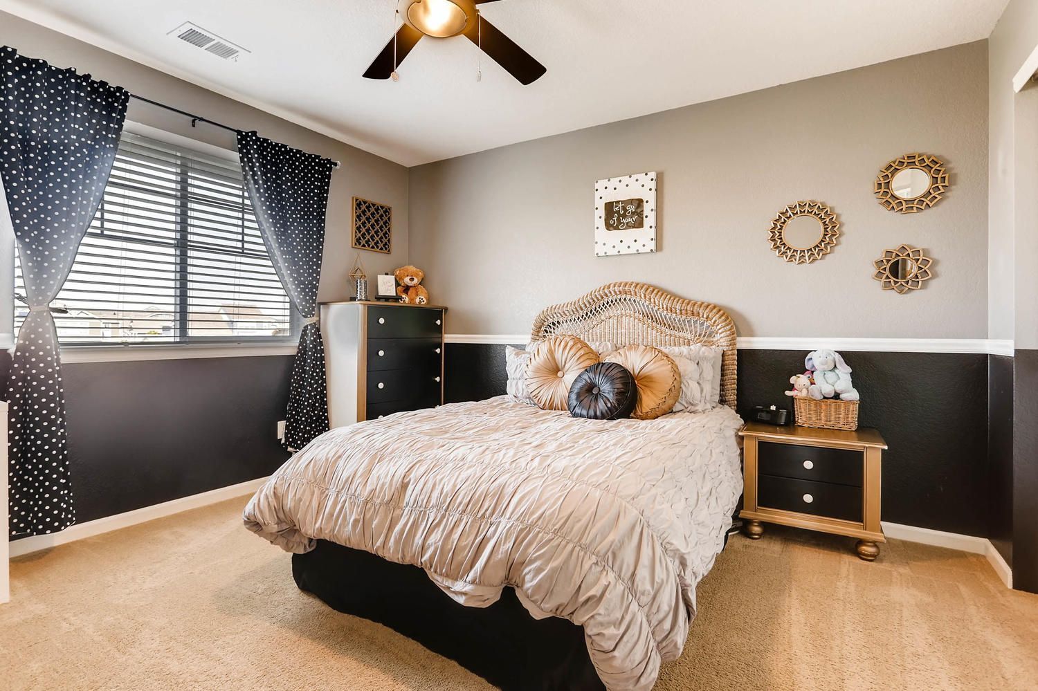 A bedroom with a bed , nightstand , dresser and ceiling fan.