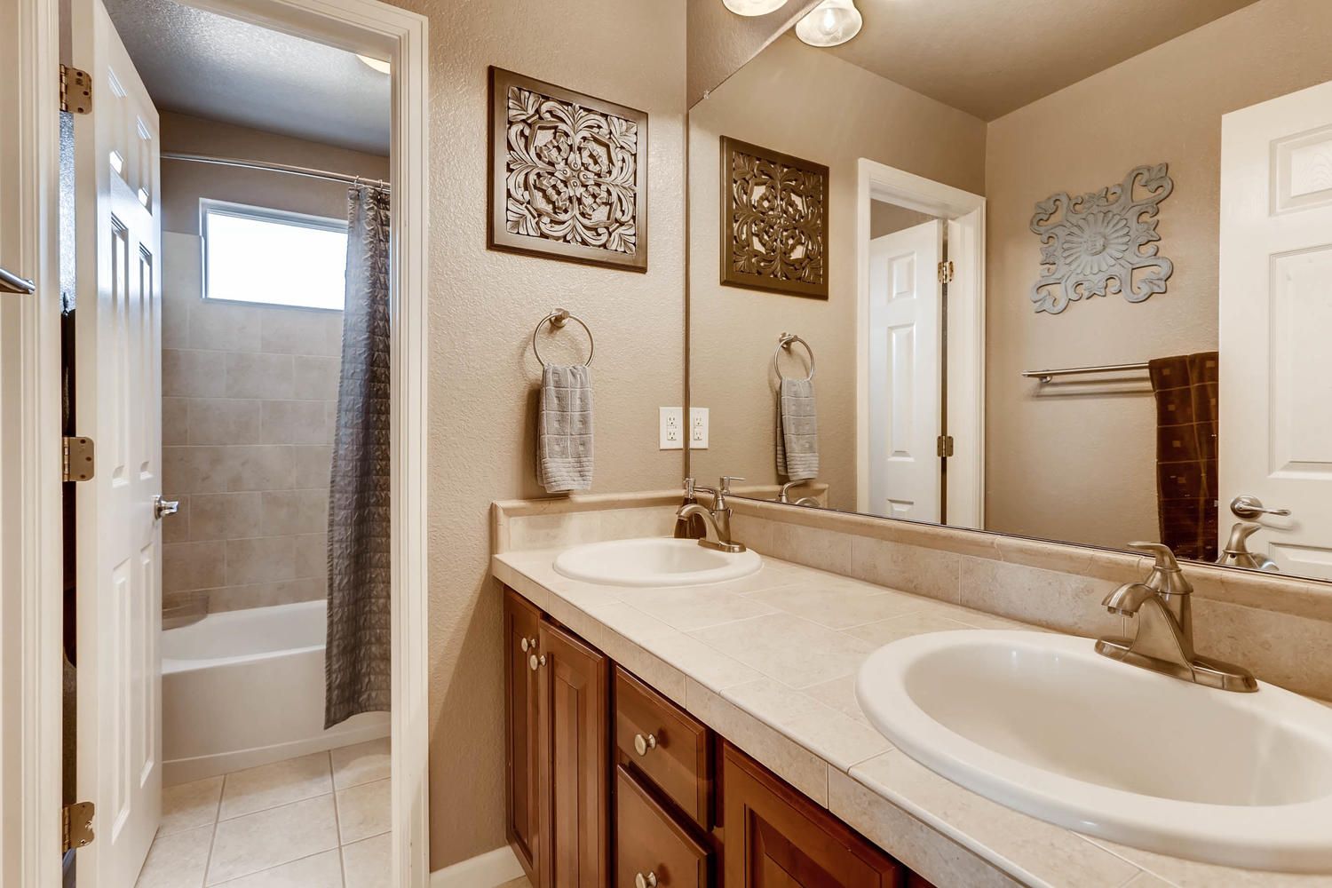 A bathroom with two sinks and a large mirror.