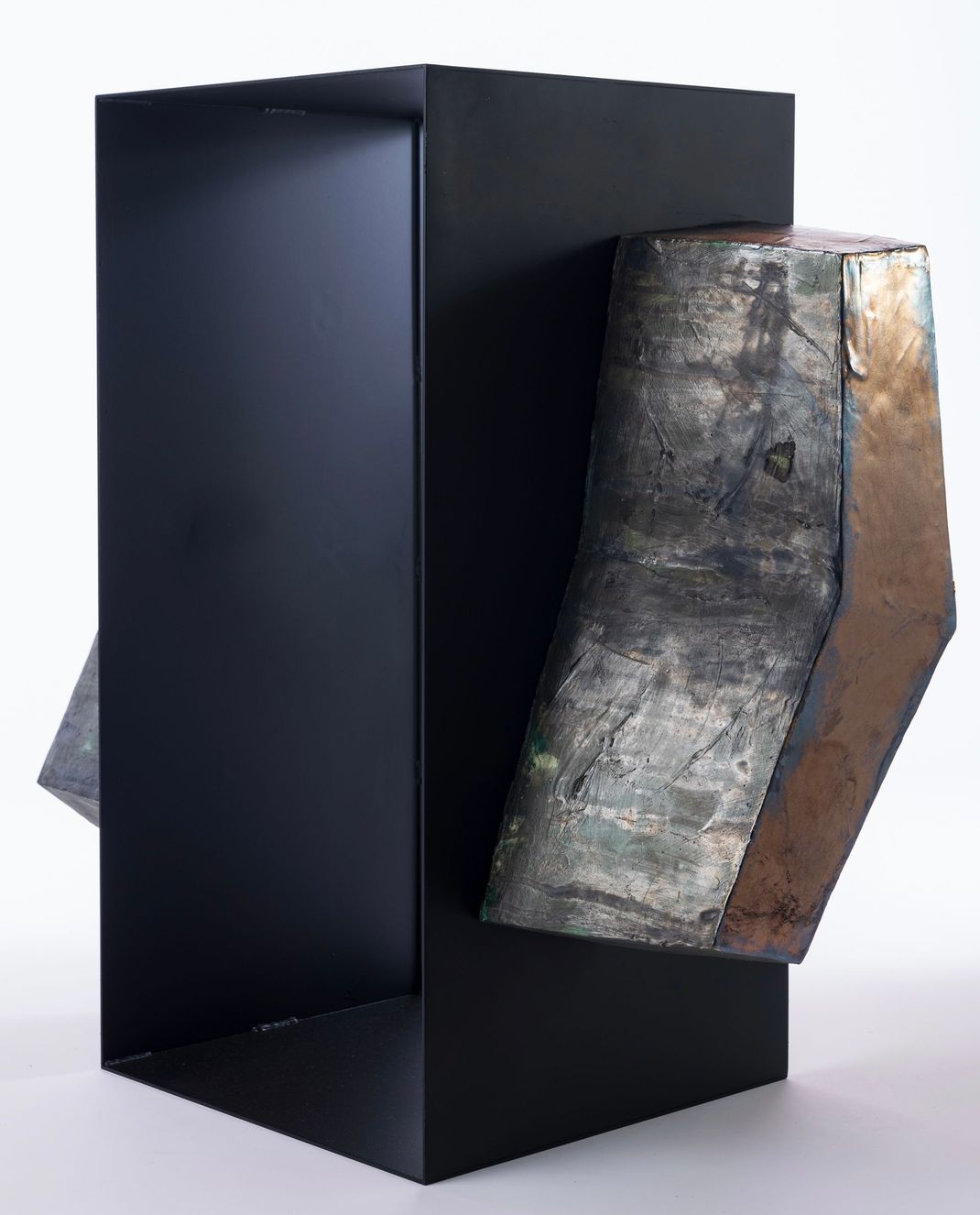 Ceramic sculpture by Japanese artist Chisato Yasui. The piece features a central part made of black metal, adorned with two ceramic pieces on the sides. The central part is hollowed out.