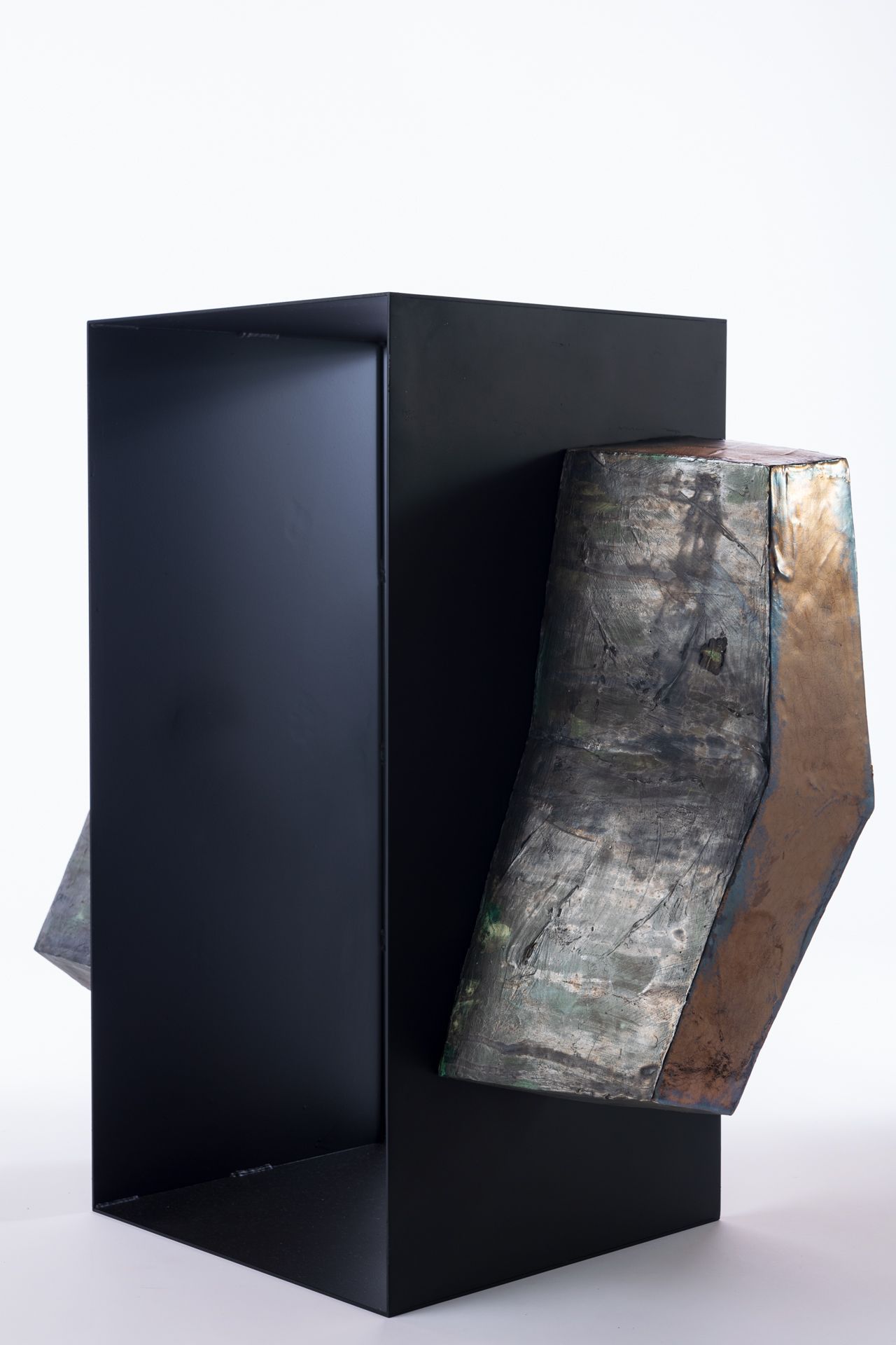 Sculpture en céramique de l'artiste japonaise Chisato Yasui. Cette œuvre comporte une partie centrale en métal noir, flanquée de deux pièces en céramique de chaque côté. La partie centrale est évidée.