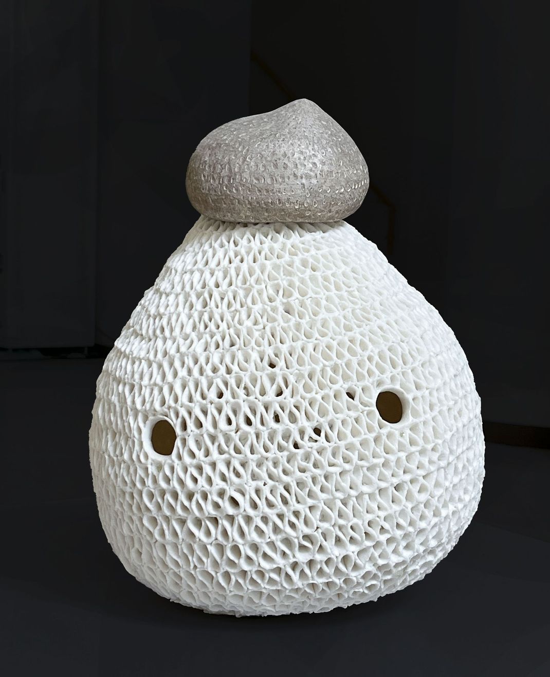 Ceramic sculpture by Japanese artist Teruri Yamawaki. A rounded work, where only the eyes are depicted. The diversity of human personalities and emotions is reflected in her creations. She considers her work to be a living entity, or even a talisman capable of bringing peace to the viewer.