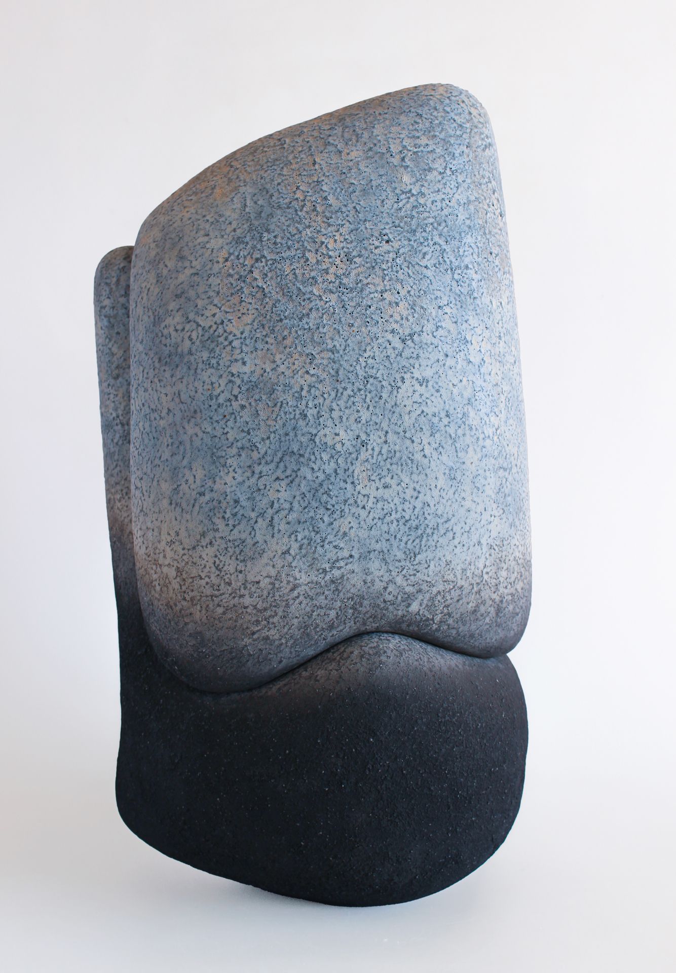 Sculpture en céramique de l'artiste japonais Kenji Gomi. De forme verticale, elle est composée de deux parties qui s'emboîtent parfaitement. L'œuvre arbore une texture évoquant des roches, avec des teintes bleues dues au cobalt ainsi que des parties noires obtenues par enfumage.