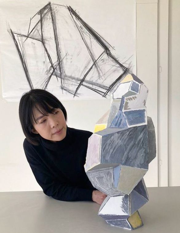 Portrait of the contemporary Japanese artist Chisato Yasui alongside one of her sculptures