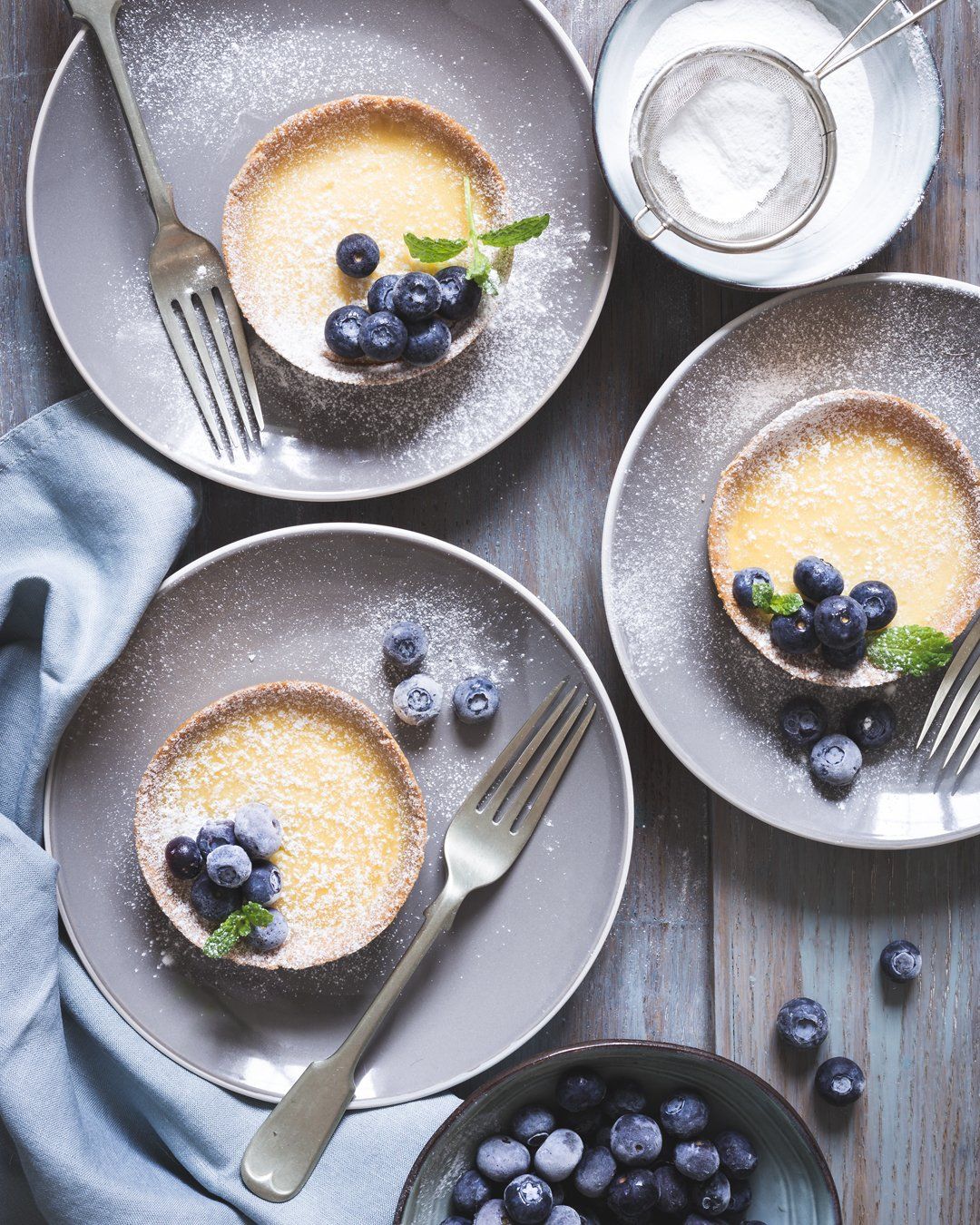 Food photography, flat lay of lemon tarts with blueberries