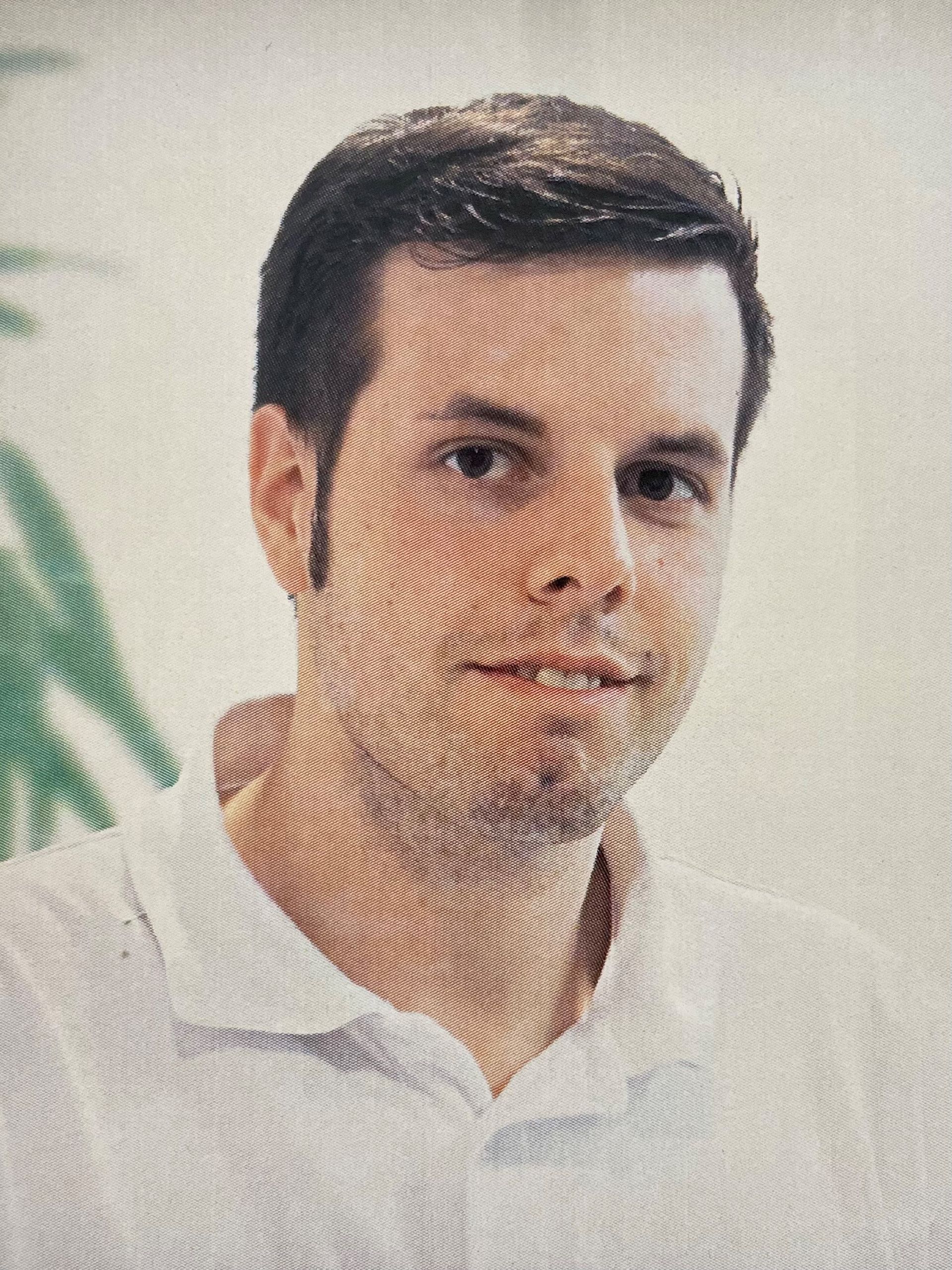 Ein Mann in einem weißen Hemd lächelt in die Kamera