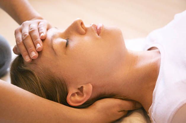 Eine Frau bekommt von einer Person eine Kopfmassage.