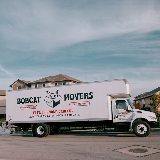 A bobcat movers truck is parked in front of a house