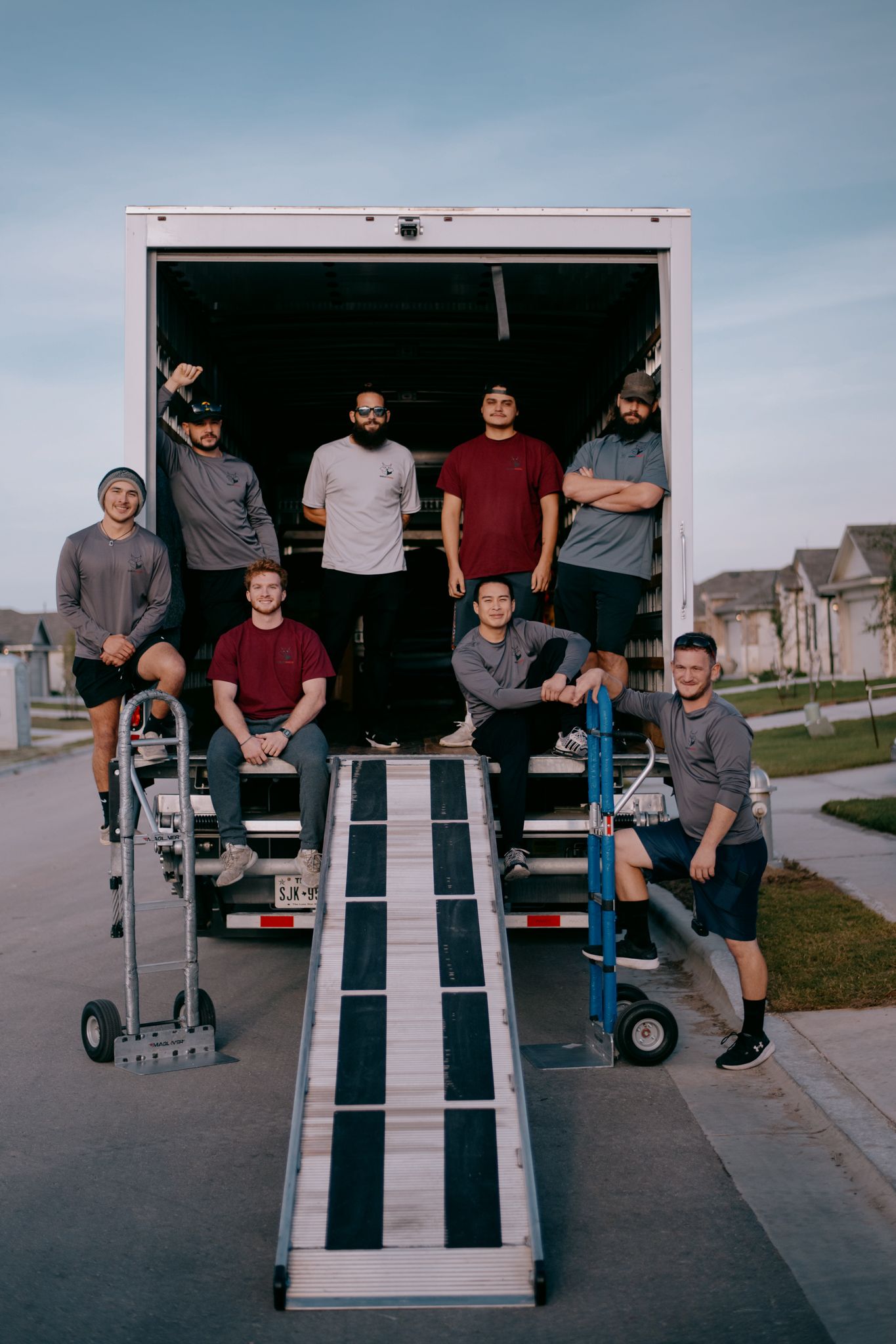 A group of men are standing in front of a moving truck.