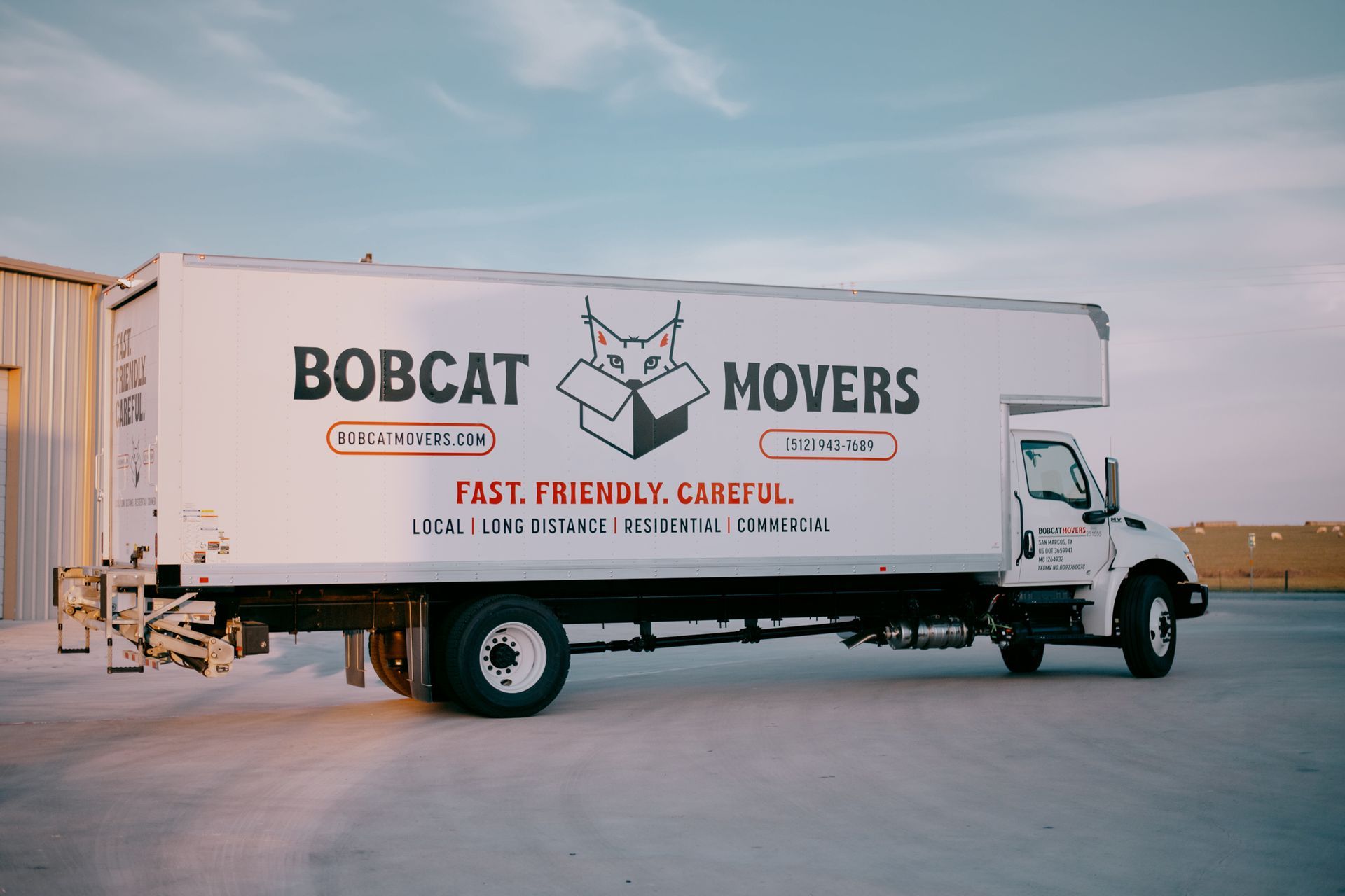 A bobcat movers truck is parked in front of a building.