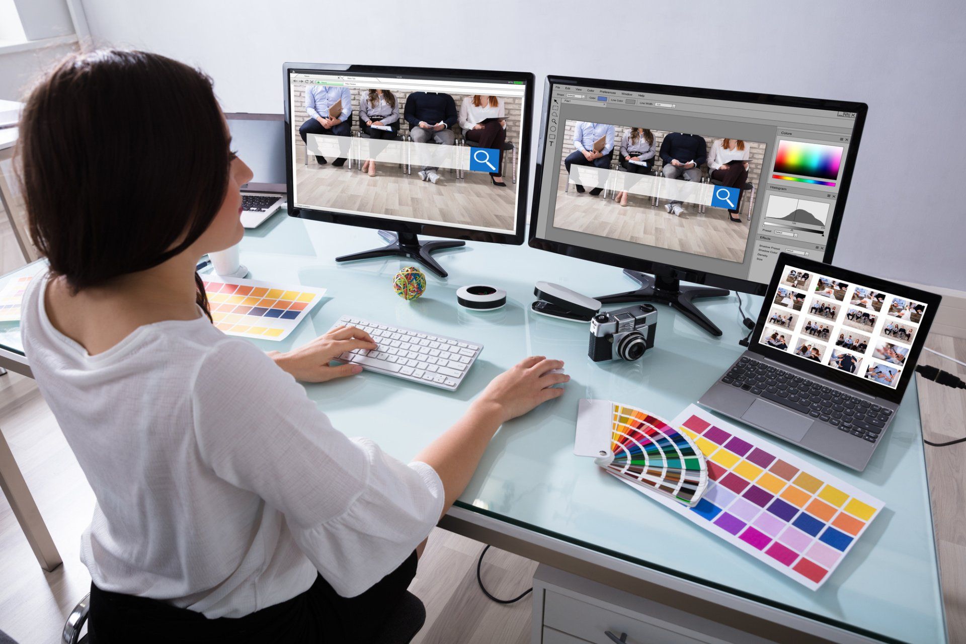 A woman is sitting at a desk working on a computer.