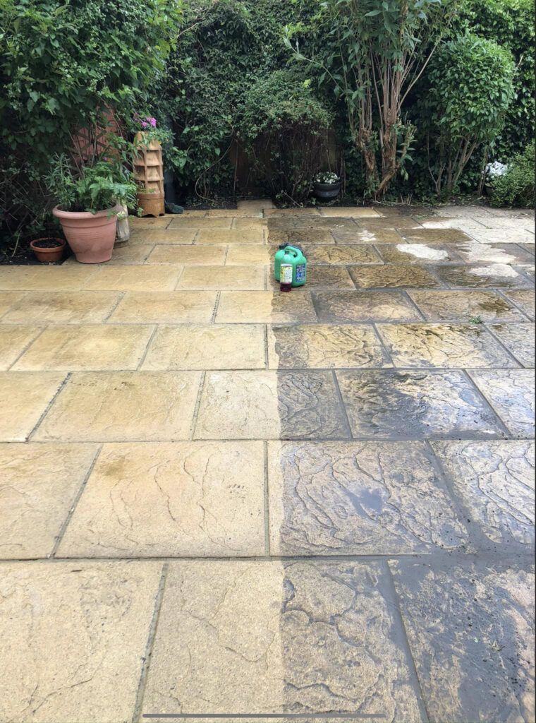 Patio being cleaned with a pressure washer; left side dirty, right side clean.