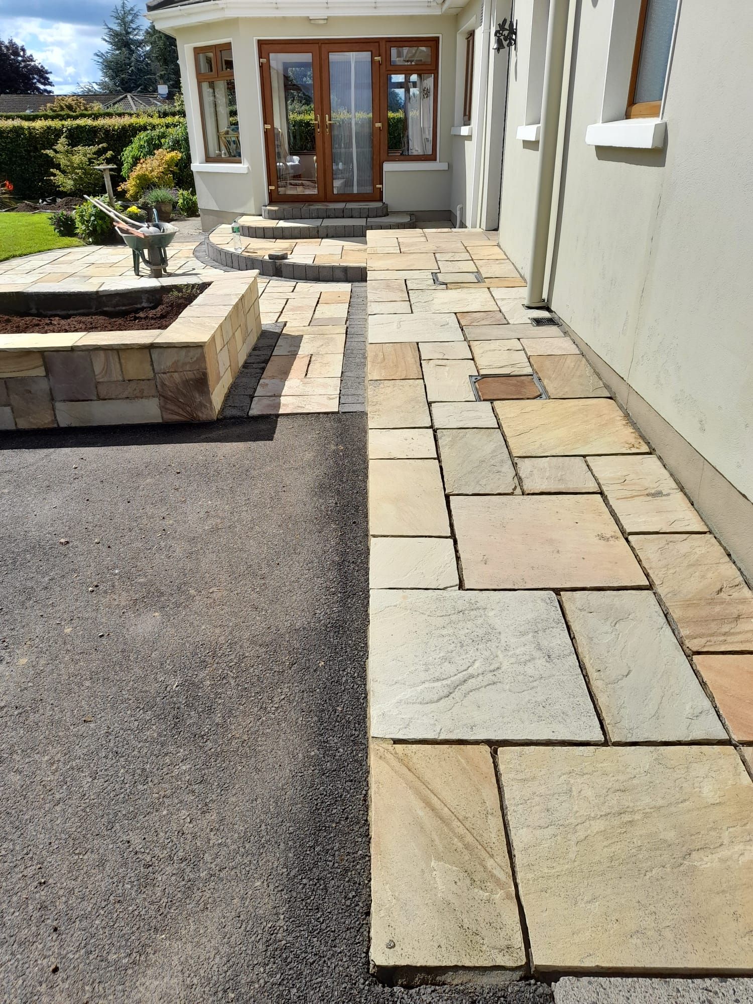 Stone patio and driveway with a building entry.