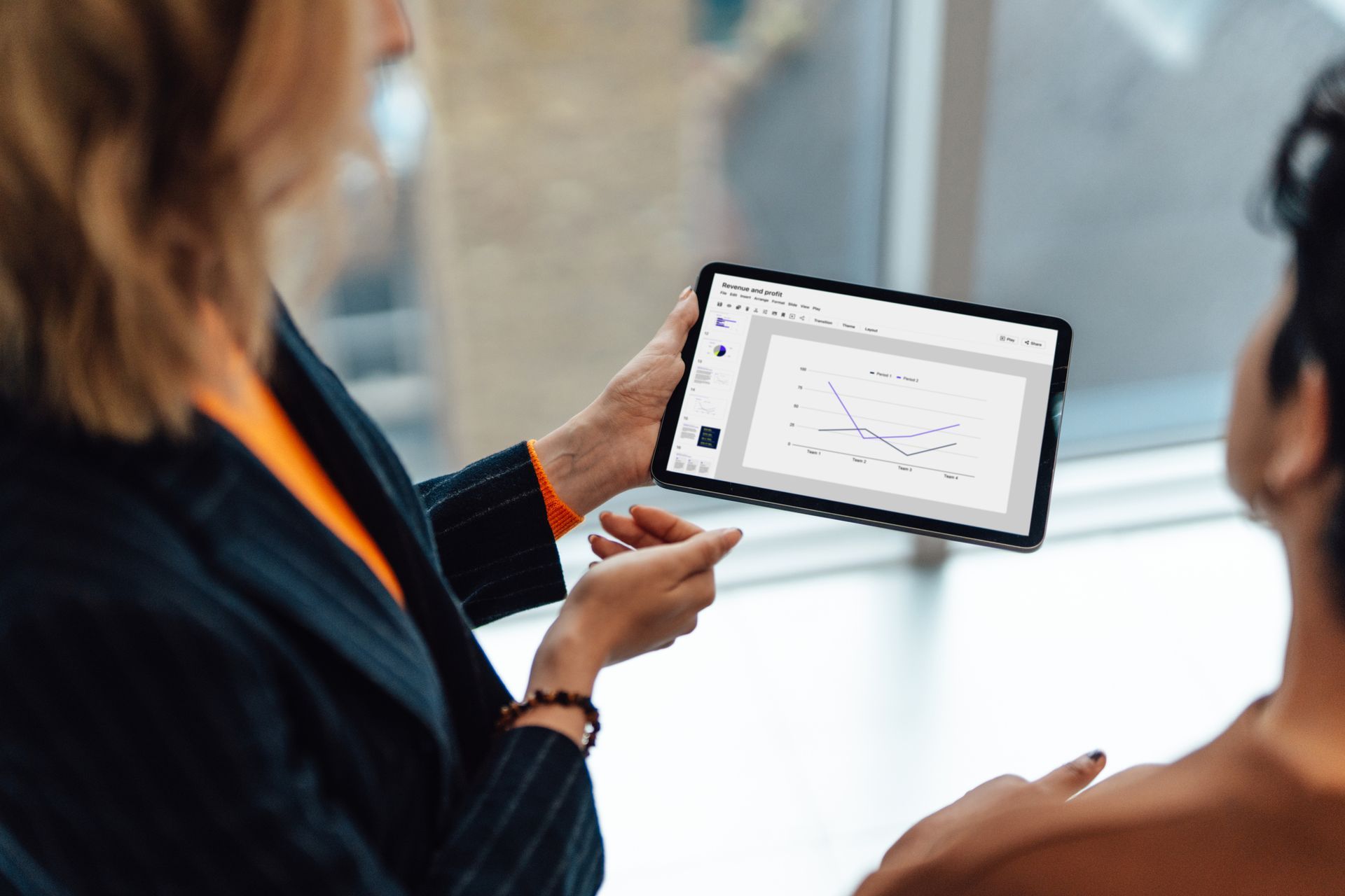 Two professionals reviewing paperwork with a calculator and laptop on a desk. Two professionals reviewing paperwork with a calculator and laptop on a desk.