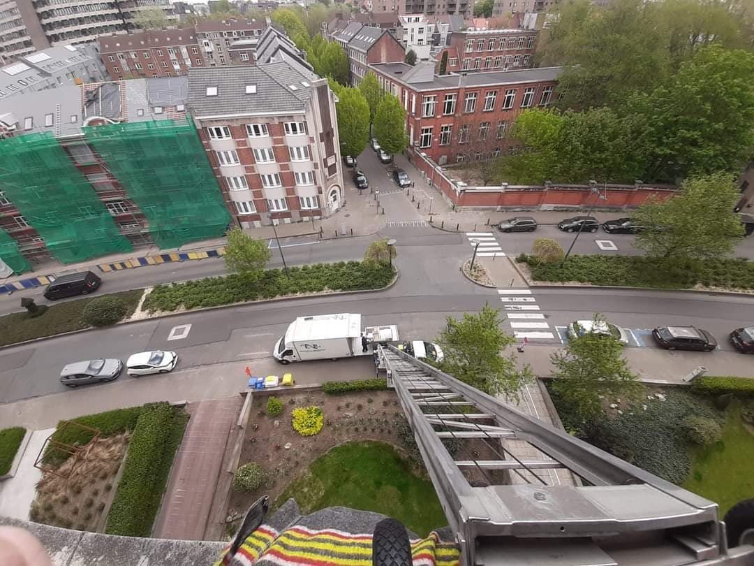 Vue aérienne d'une intersection de la ville avec des bâtiments, des voitures et un camion avec une plate-forme surélevée.
