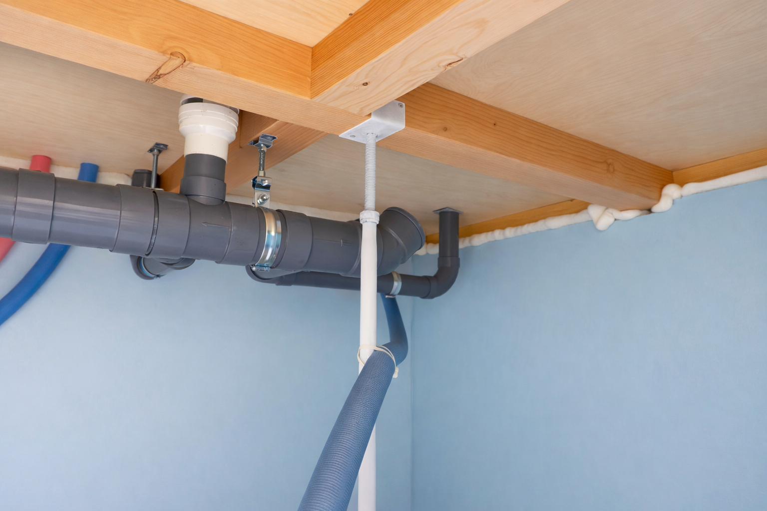 Plumbing tools on top of a water heater with pipes and connections.
