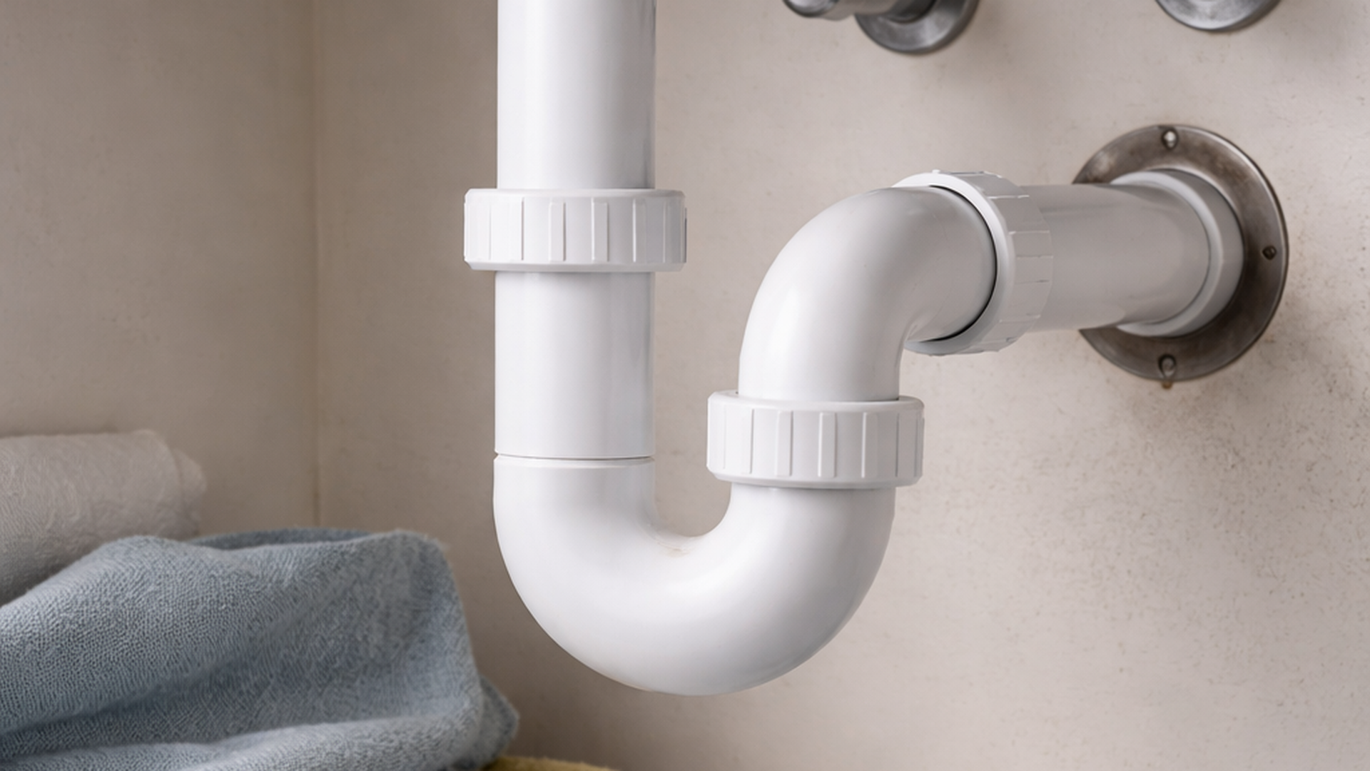 Black and white close-up of a chrome faucet with water dripping.