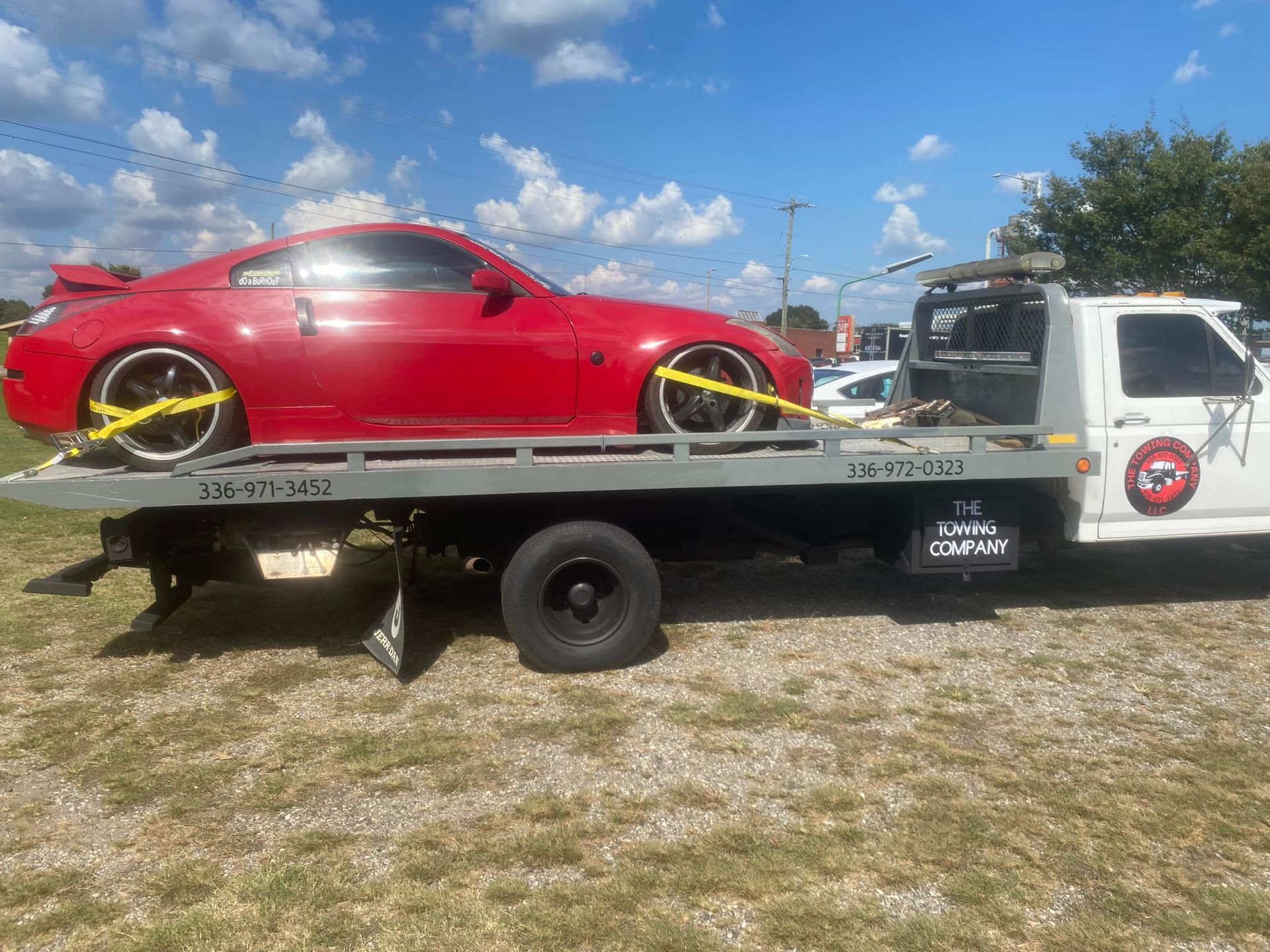 A red sports car is sitting on top of a tow truck.