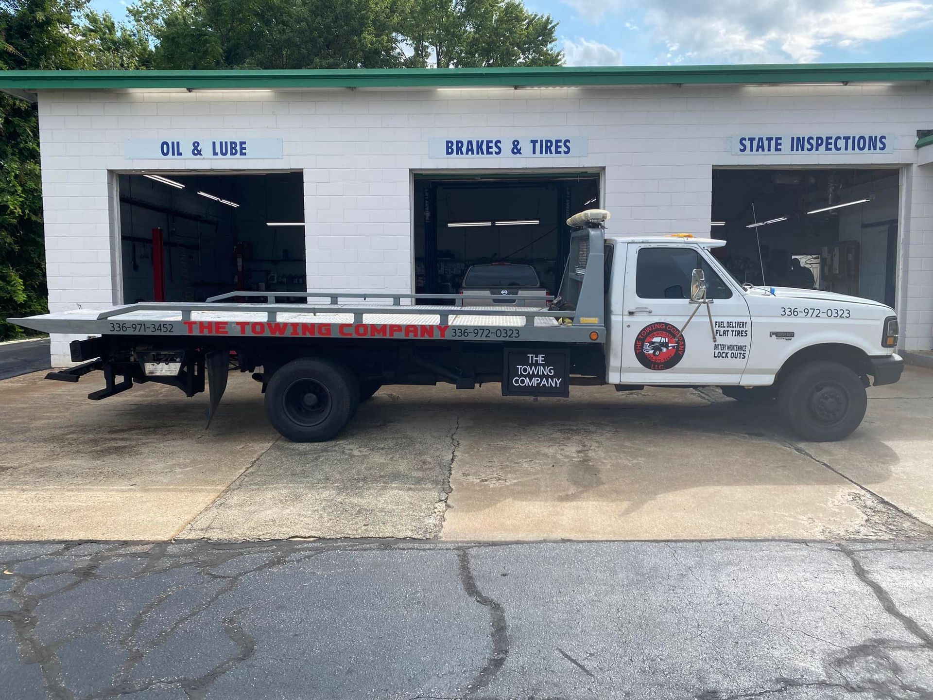 A tow truck is parked in front of a garage.