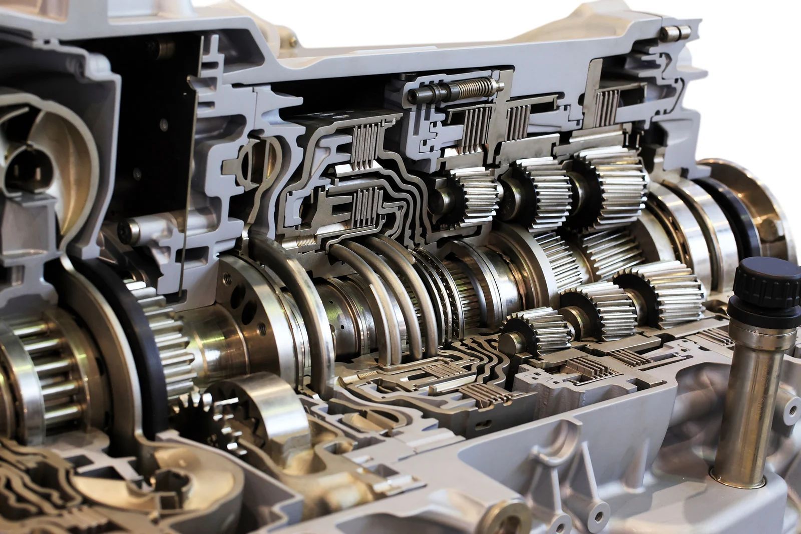 Cutaway view of an automatic transmission showing gears, shafts, and hydraulic components in a metal housing.