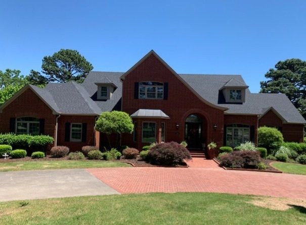 A large red brick house with a black roof