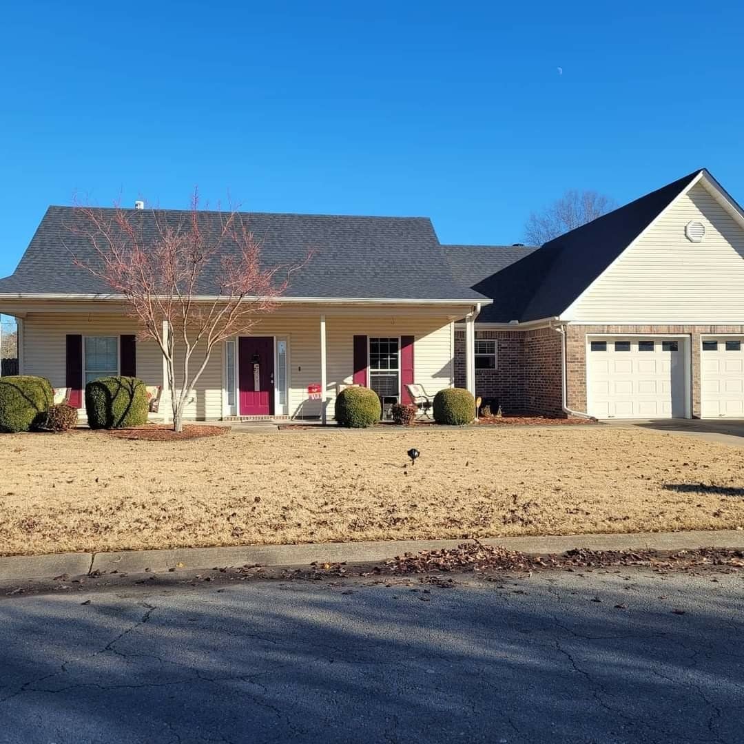 A white house with a gray roof and a red door
