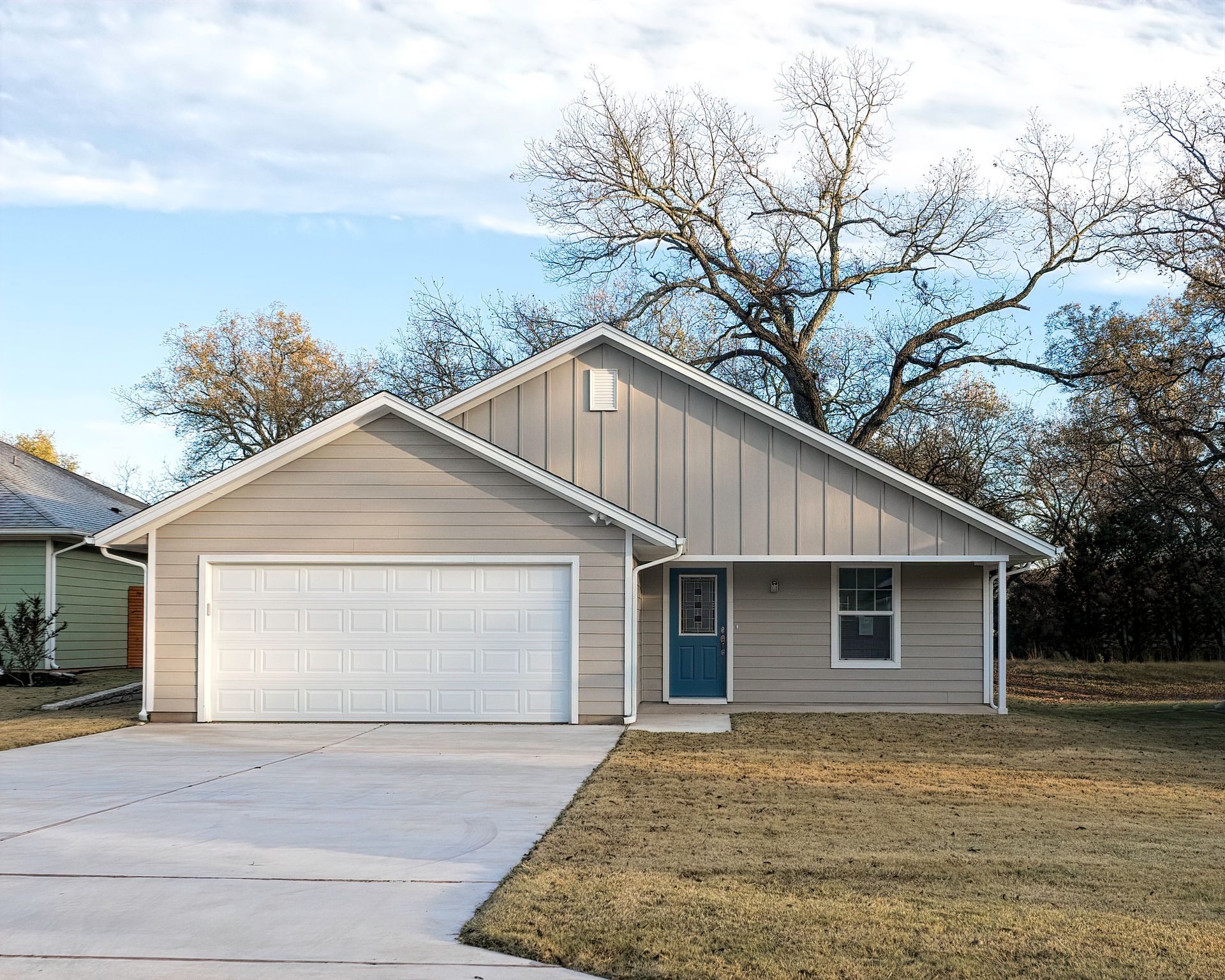A house with a garage and a driveway in front of it.